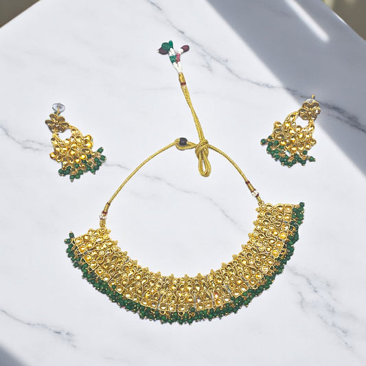 Kundan Emerald Whisper Jewelry Set – Artificial gold-tone necklace and earrings featuring emerald stones and Kundan detailing.