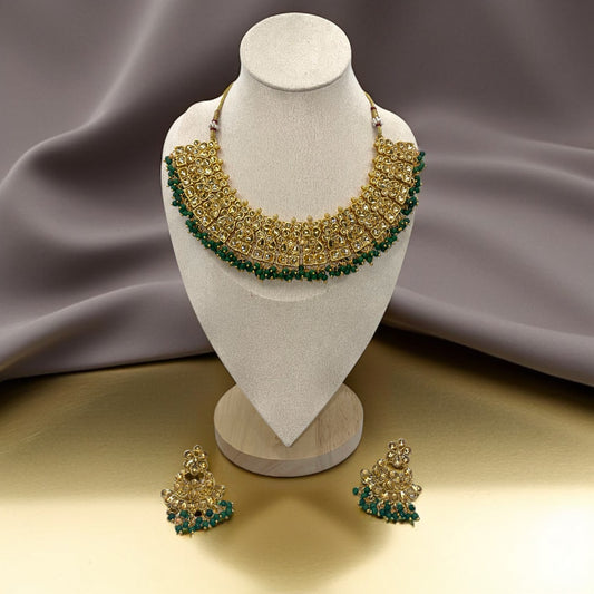 Kundan Emerald Whisper Jewelry Set – Artificial gold-tone necklace and earrings featuring emerald stones and Kundan detailing.